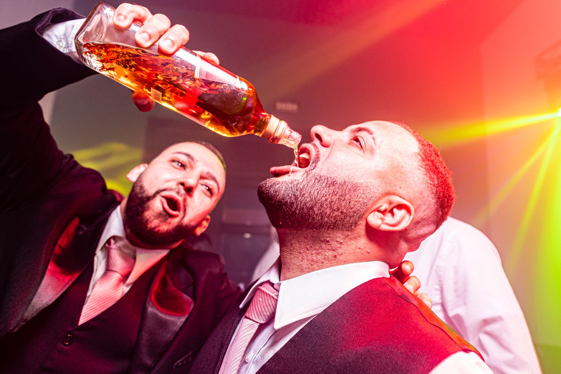 Vibrant nightlife party with men celebrating and pouring drinks.
