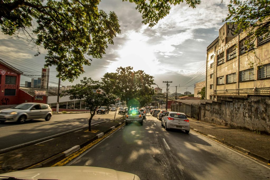Traffic on a sunny urban street with cars and city buildings in view.