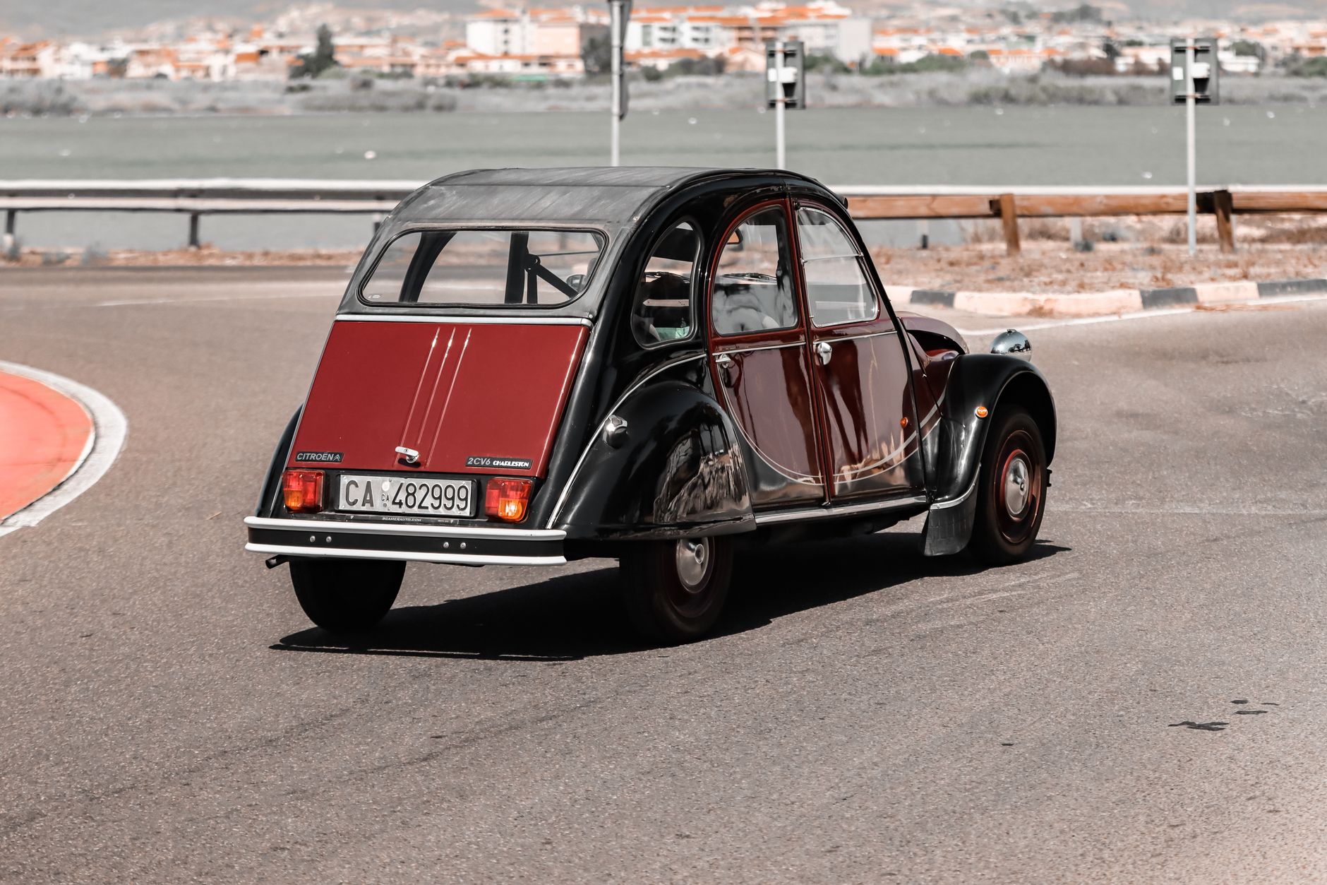 A classic Citroën 2CV car navigating the streets of Cagliari, Sardinia, Italy.