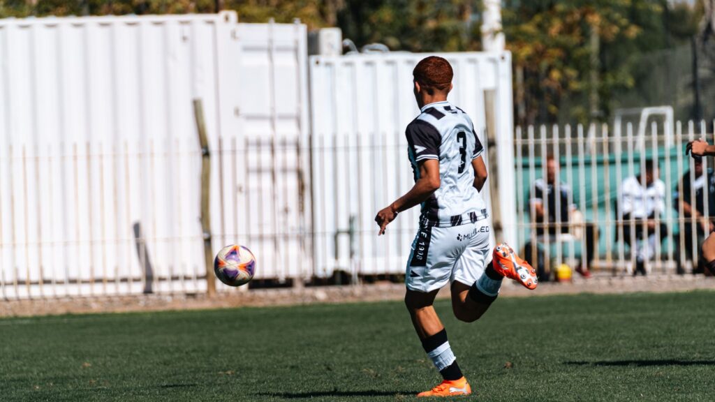 A young soccer player in action on a sunny day outdoors.