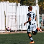 A young soccer player in action on a sunny day outdoors.