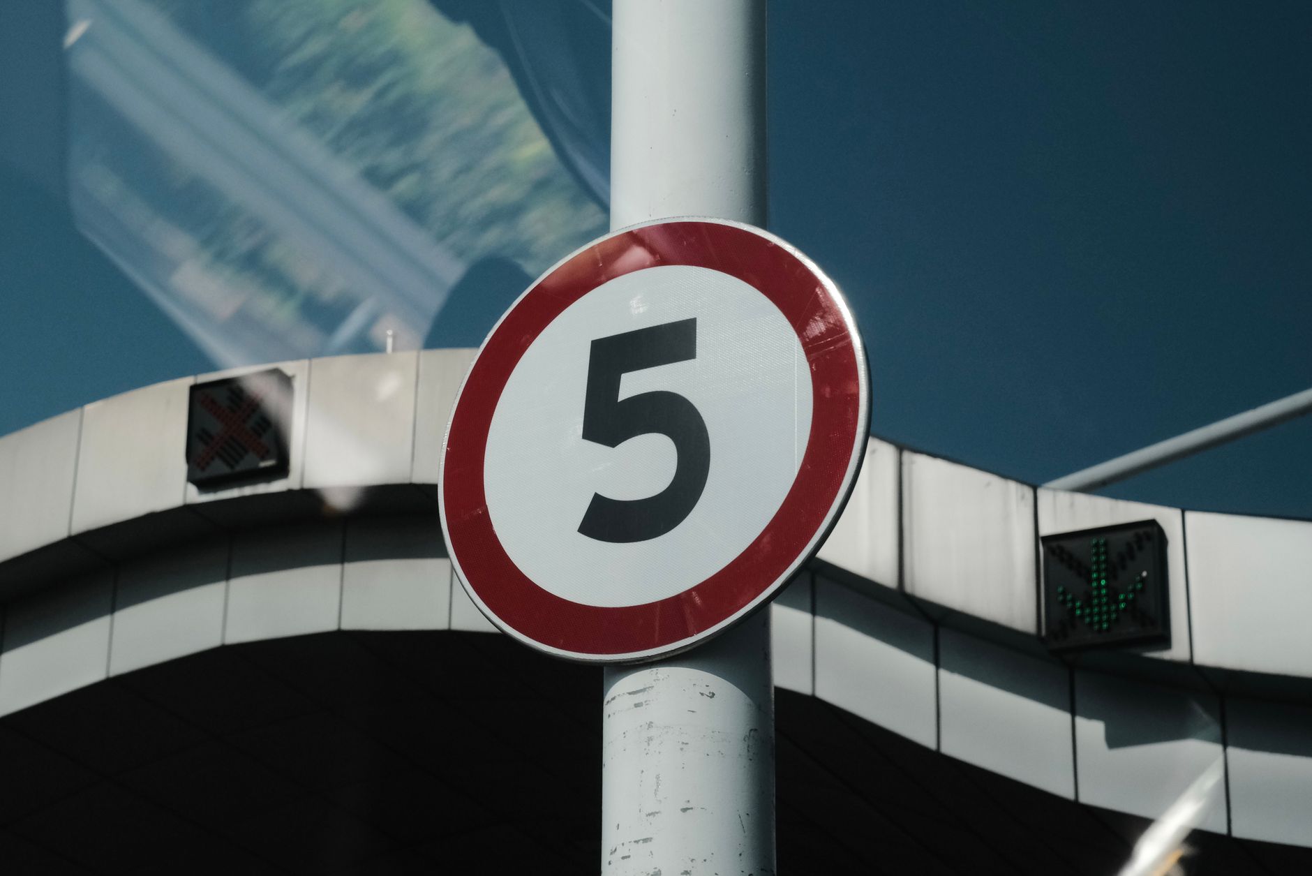 Close-up of a speed limit sign on a street pole in an urban setting.