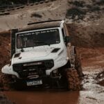 Close-up of a jeep navigating a muddy track during an off-road adventure event.