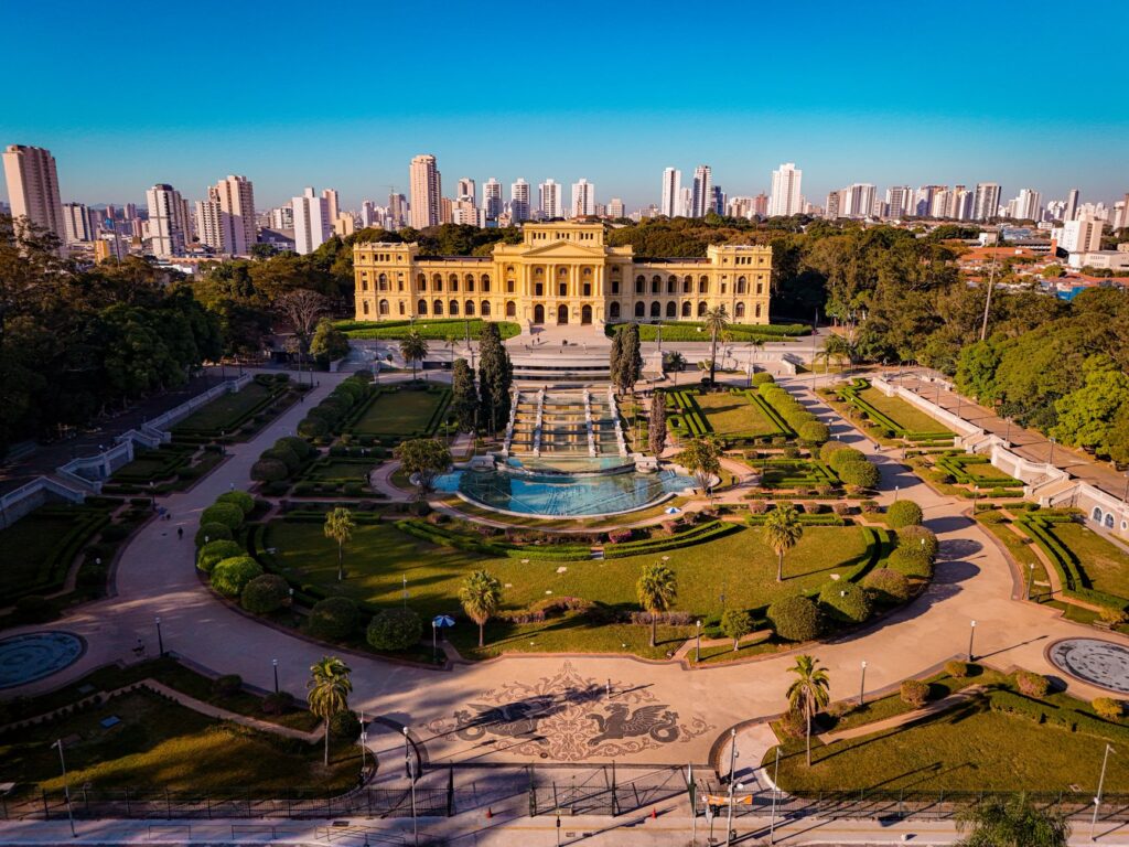 An aerial shot of the iconic Ipiranga Museum with lush gardens, captured in São Paulo, Brazil.