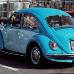 Classic blue Volkswagen Beetle parked on a street in Porto, Portugal.