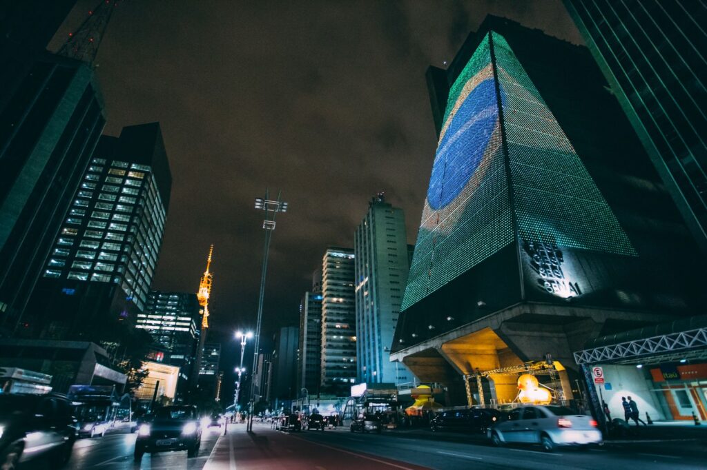 A dynamic nighttime cityscape in Sao Paulo featuring modern skyscrapers and street lights.