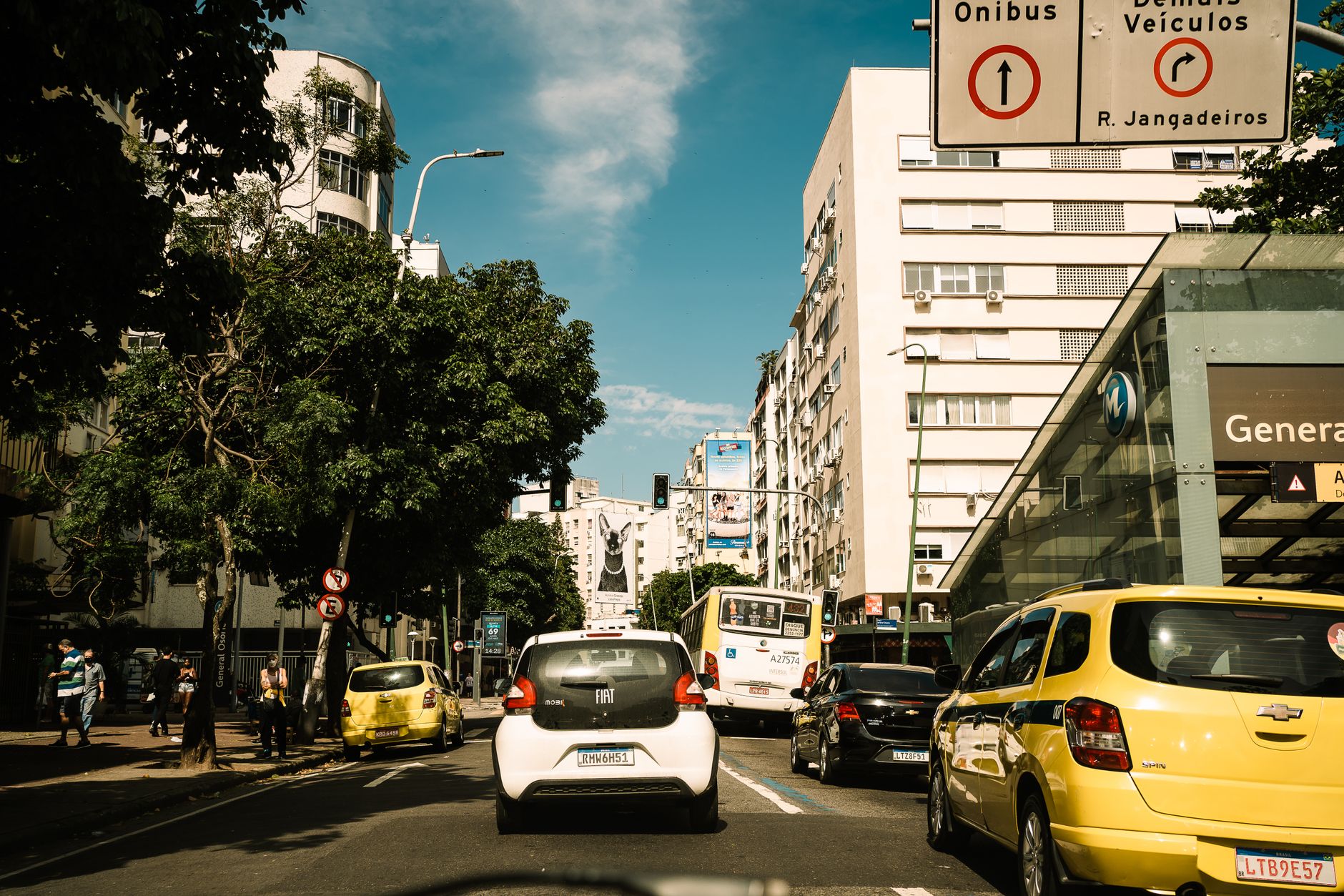 Capture of a lively street in Rio de Janeiro, featuring traffic and pedestrians on a sunny day.