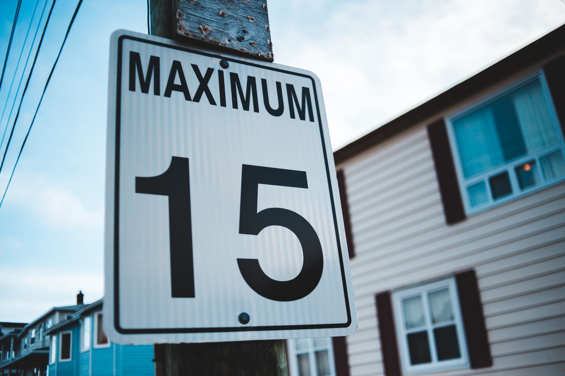 Regulatory road sign with Maximum inscription and number 15 against house facade in city in daytime