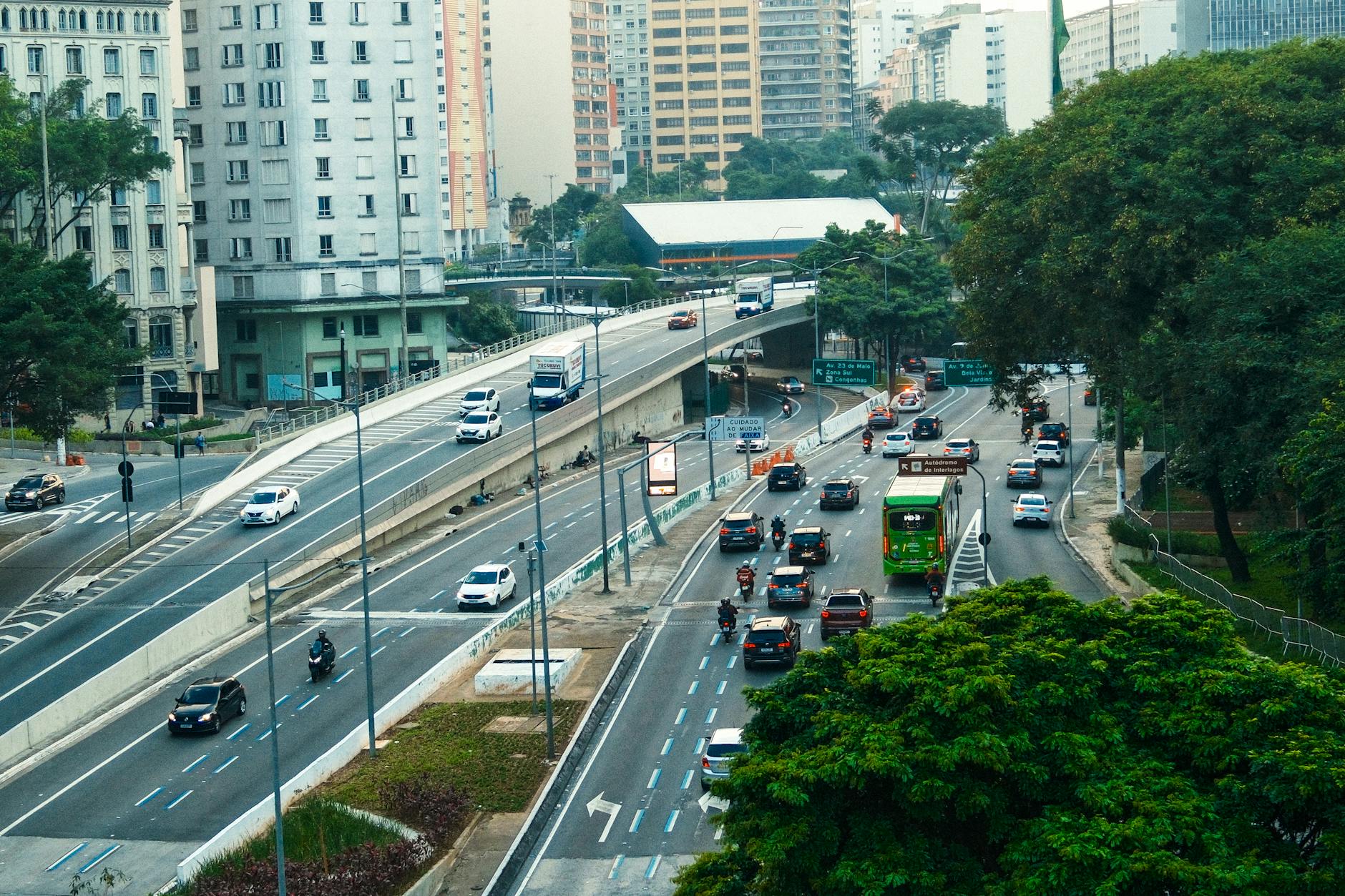 An overhead view showcasing the bustling traffic on a São Paulo highway amid green urban surroundings.