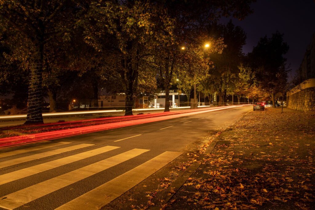 Captivating night view of a road in autumn with light trails and trees in São João da Madeira, Portugal.