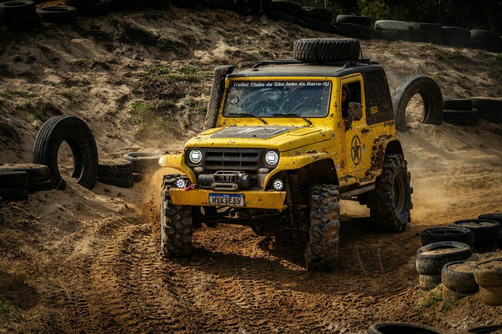 Dynamic image of a rugged yellow off-road vehicle on a dirt track, showcasing adventure and thrill.