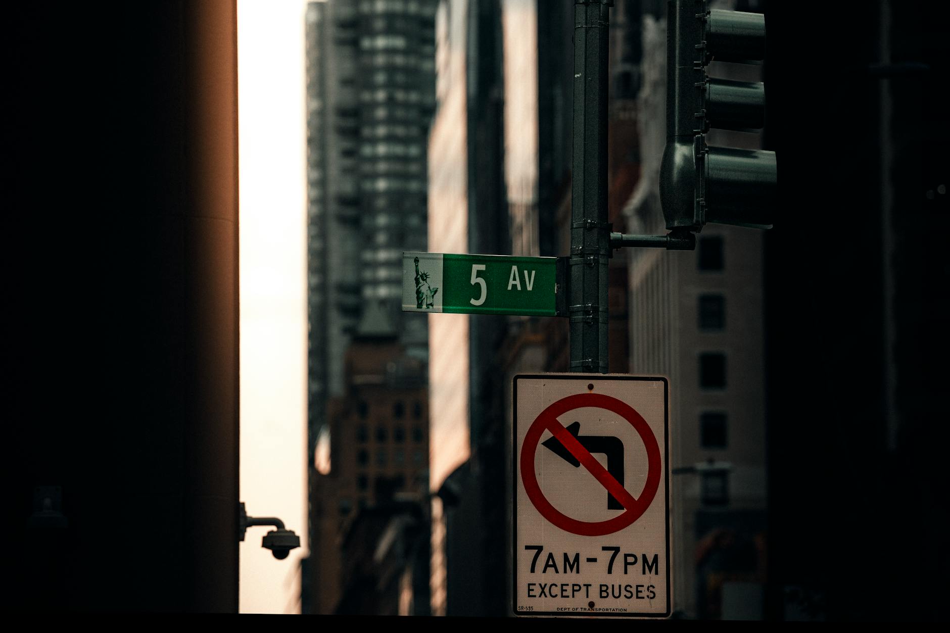 Moody urban scene of 5th Avenue street sign with tall buildings in NYC.