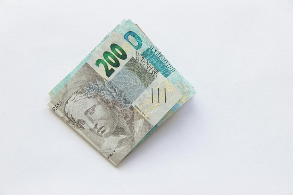 Stack of 200 Brazilian Real banknotes isolated on a white surface, symbolizing wealth and finance.
