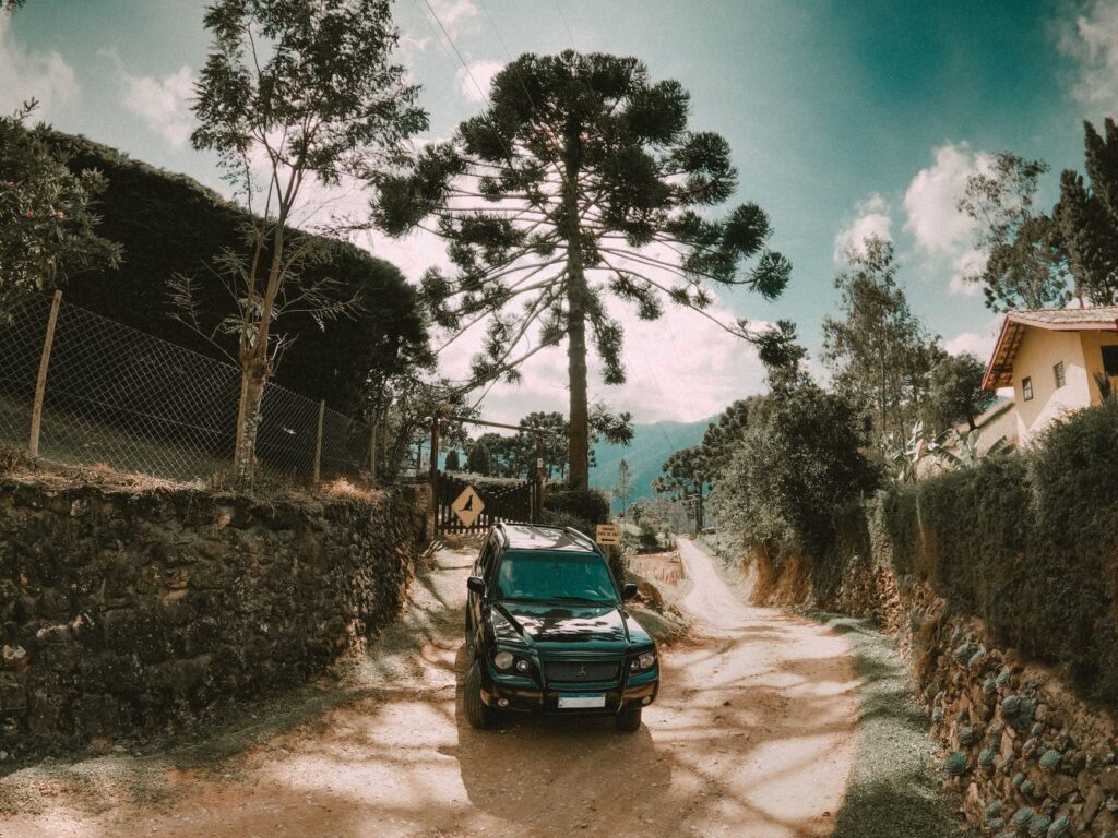 Black SUV parked on a scenic dirt road surrounded by nature in São Bento do Sapucaí, Brazil.