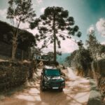 Black SUV parked on a scenic dirt road surrounded by nature in São Bento do Sapucaí, Brazil.