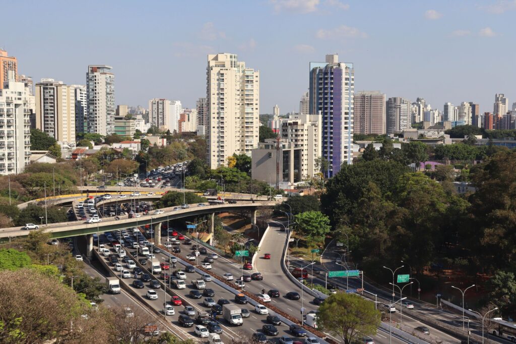 Aerial view of a bustling expressway and urban skyline in São Paulo, Brazil.