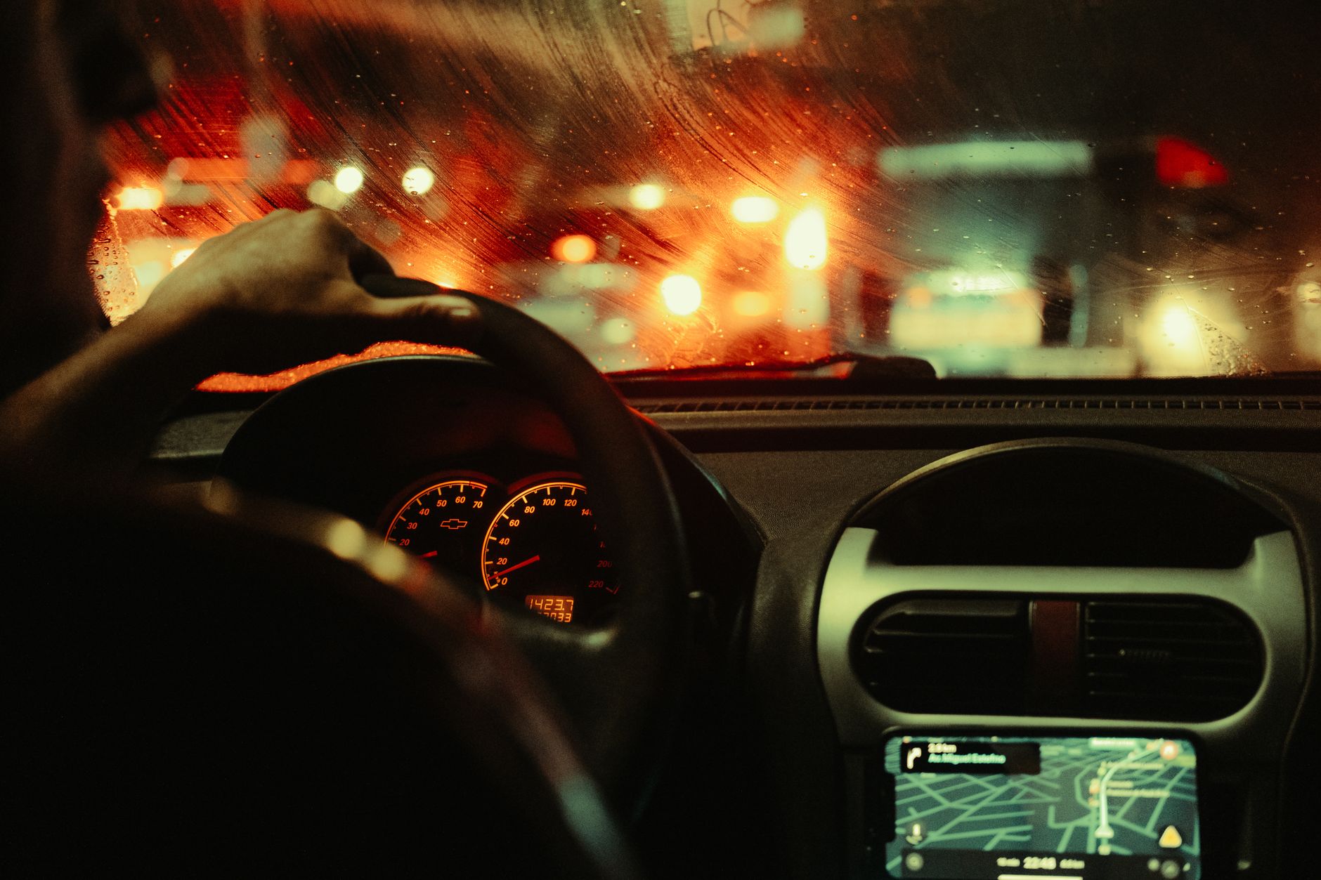 A man's perspective driving through São Paulo at night, focusing on city lights and traffic.