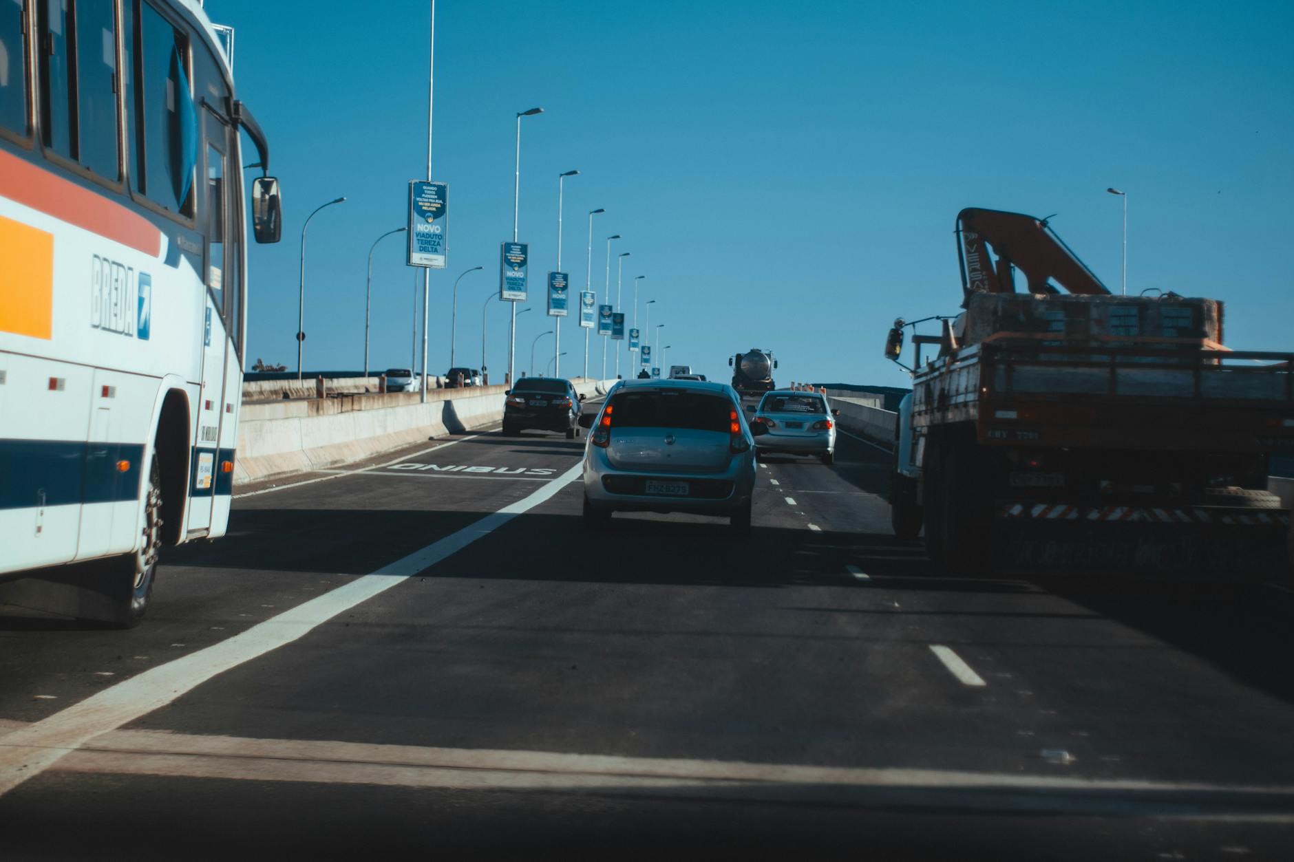 Busy urban expressway filled with vehicles in motion under a clear blue sky, showcasing modern transportation.
