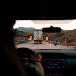 Scenic drive with a truck on a highway surrounded by hills. Perfect for travel themes.