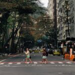 People crossing a street in Copacabana, Rio de Janeiro, surrounded by urban architecture.
