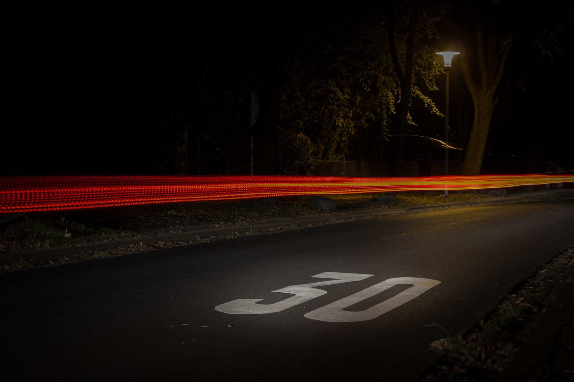 A long exposure night street scene in Mönchengladbach showcasing vibrant car light trails.