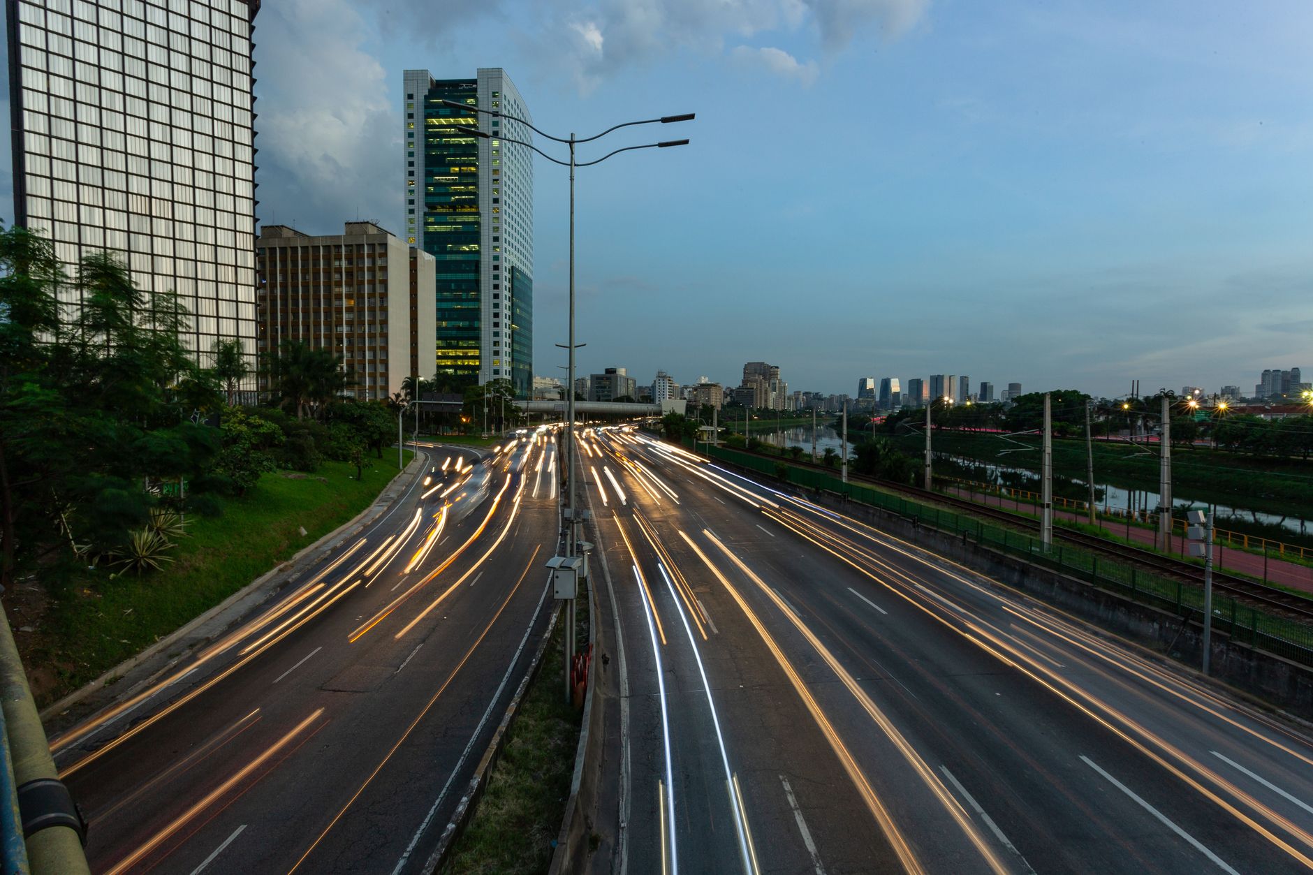 Dynamic night cityscape featuring moving traffic light trails and modern buildings.