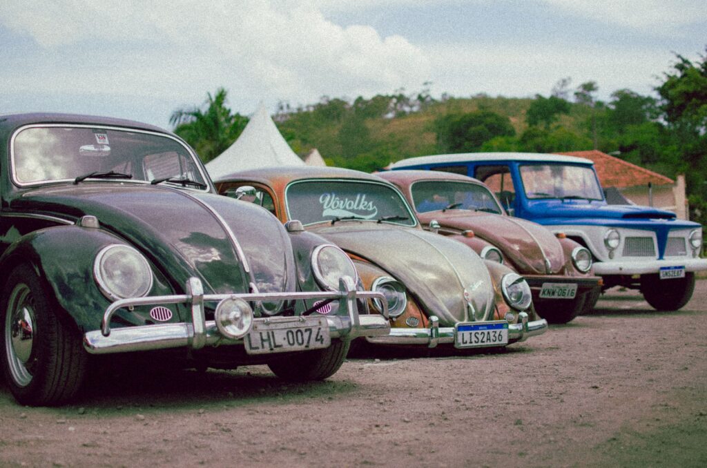 Collection of vintage Volkswagen cars parked outdoors, showcasing retro style.