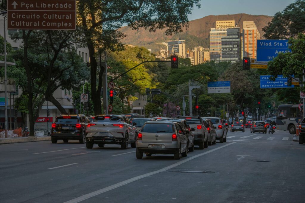 A bustling city street scene with cars and buildings at sunset in Belo Horizonte, Brazil.