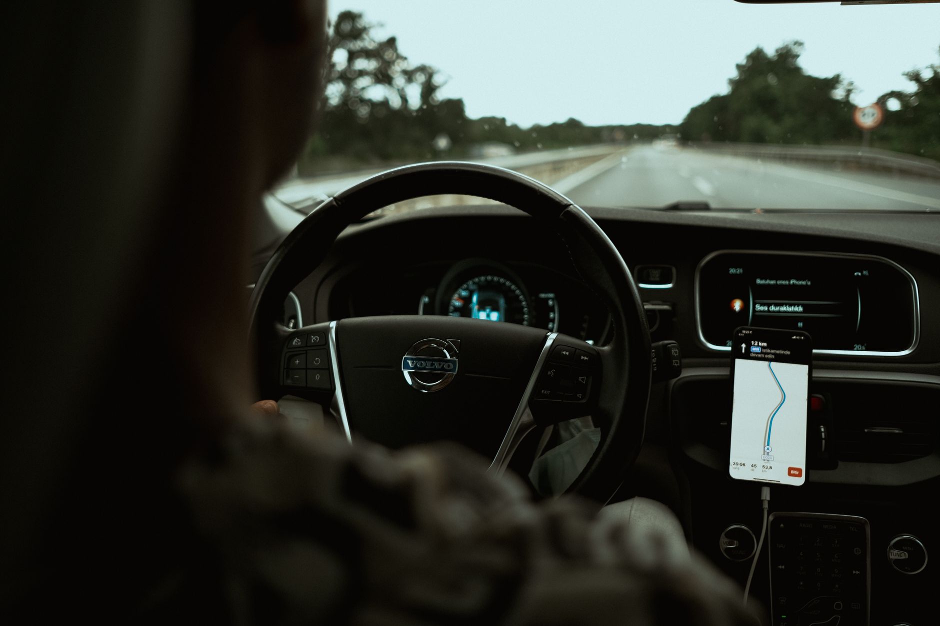 Interior view of a car on the highway using a GPS navigation app on a smartphone