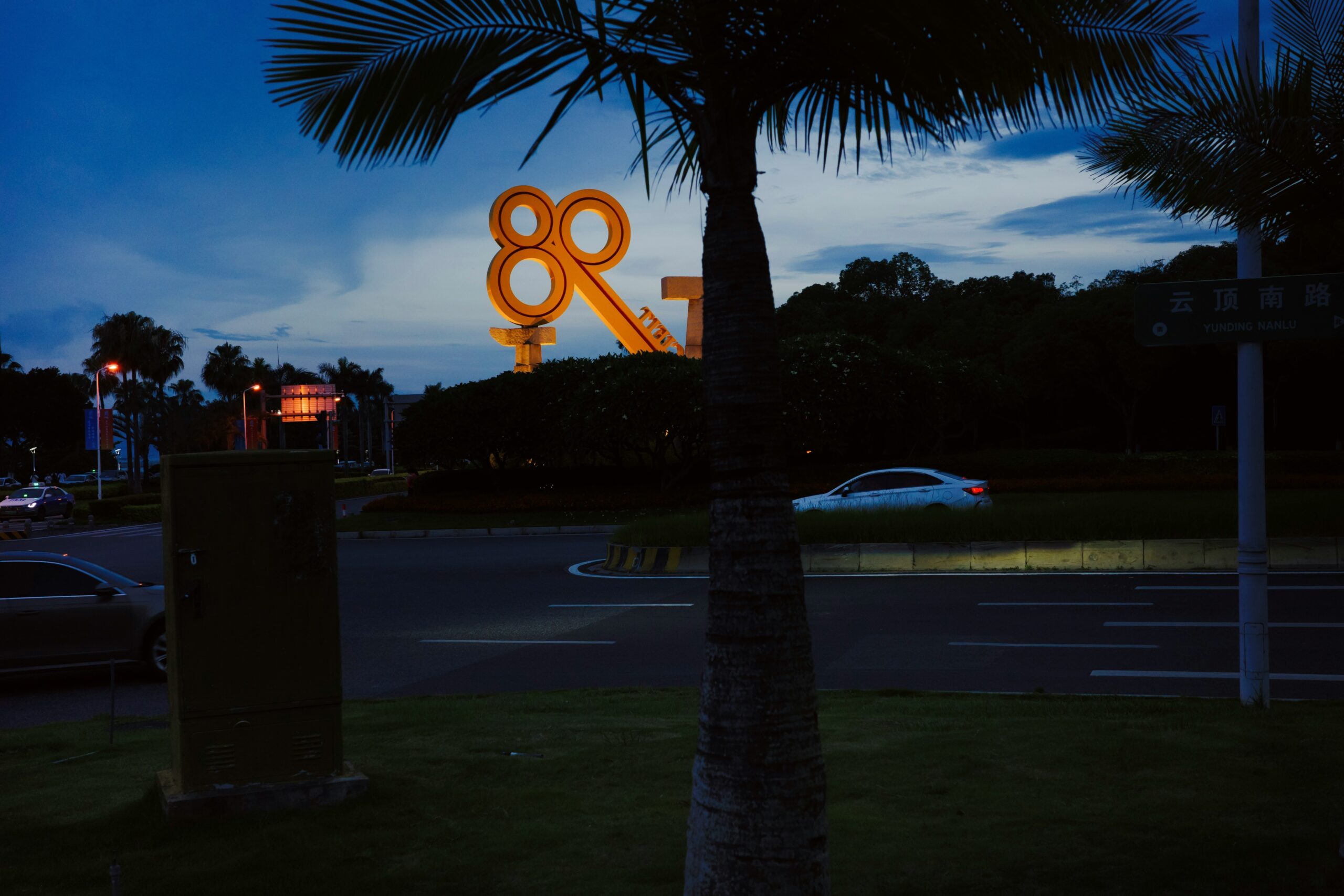 Large illuminated ampersand sign at dusk.