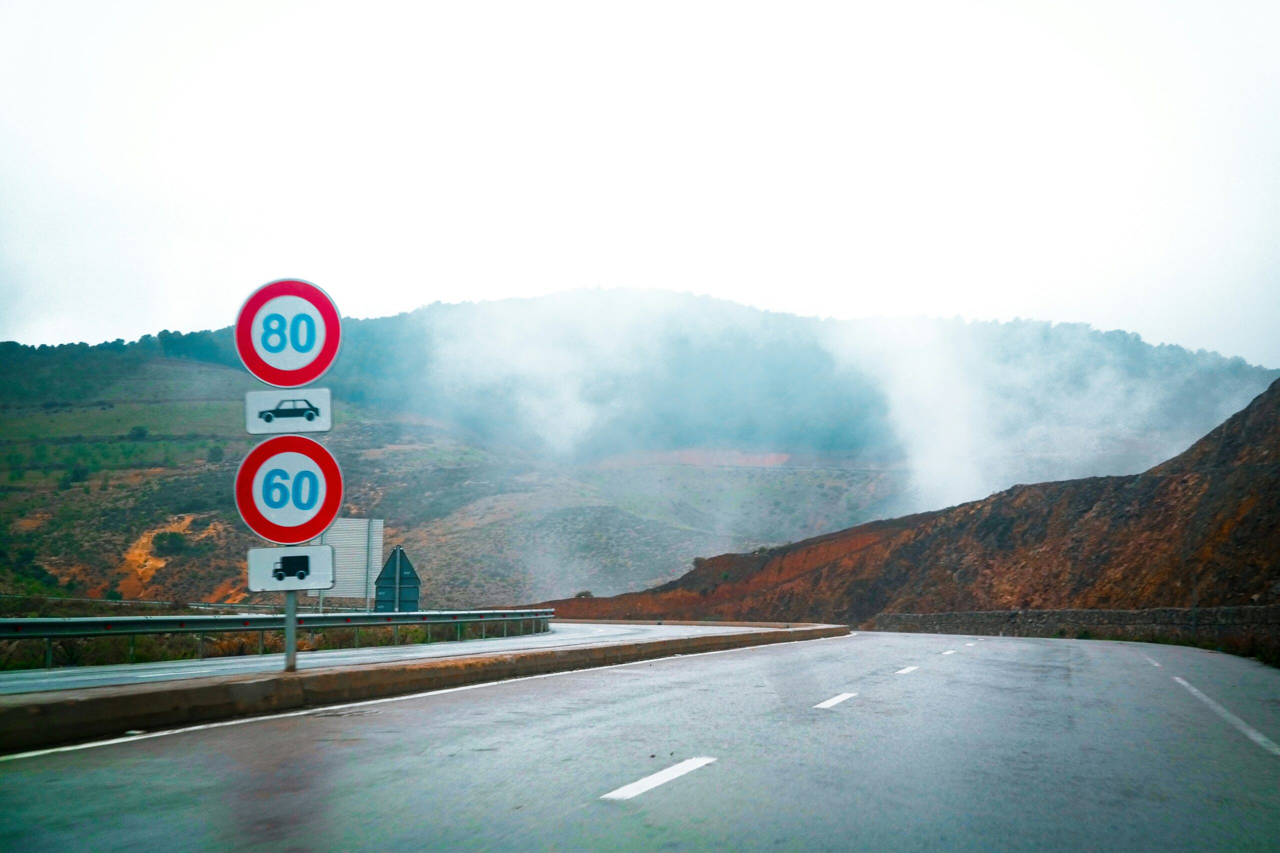 A road with a speed limit sign and a speed limit sign