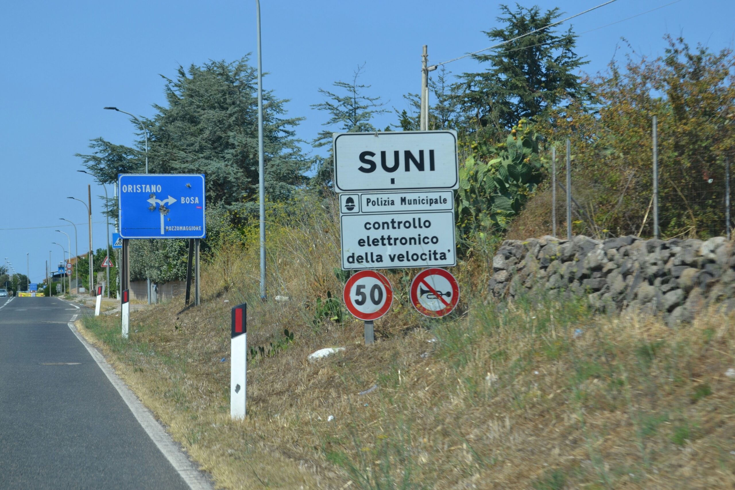 Road signs indicating the town of suni and speed limit.